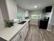 Modern kitchen with white shaker cabinets, quartz countertops, and stainless steel appliances at 620 Oak St, Auburndale, FL 33823