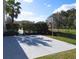 Backyard with a basketball court in a fenced yard with grassy areas and some trees at 10542 Wittenberg Way, Orlando, FL 32832