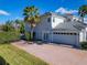 Spacious three-car garage and brick driveway complement the exterior of this home, surrounded by lush landscaping at 10542 Wittenberg Way, Orlando, FL 32832