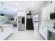 Open-concept kitchen with white cabinetry, stainless steel appliances, sleek island, and an adjoining living area at 10542 Wittenberg Way, Orlando, FL 32832