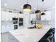 Modern kitchen featuring white cabinets, stainless steel appliances, a spacious island, and stylish pendant lights at 10542 Wittenberg Way, Orlando, FL 32832