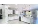 Bright kitchen with white cabinetry, stainless steel appliances, an island with marble countertop, and modern accents at 10542 Wittenberg Way, Orlando, FL 32832
