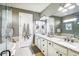 Bathroom featuring double sinks with granite countertops, white cabinetry, walk-in shower and soaking tub at 14132 Murcott Blossom Blvd, Winter Garden, FL 34787