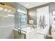 Bright bathroom featuring a walk-in shower, soaking tub, and white cabinetry at 14132 Murcott Blossom Blvd, Winter Garden, FL 34787