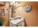 The bathroom has a granite counter, bright lights, a vessel sink, and decorated orange walls at 14132 Murcott Blossom Blvd, Winter Garden, FL 34787