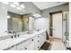 Bathroom featuring double sinks with granite countertops, white cabinetry, and walk-in shower at 14132 Murcott Blossom Blvd, Winter Garden, FL 34787