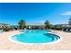 Community pool with a 4 ft 9 in depth, surrounded by lounge chairs, palm trees, and a covered outdoor seating area at 14132 Murcott Blossom Blvd, Winter Garden, FL 34787