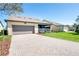 This home features a two-car garage and a paved driveway with some green landscaping at 14132 Murcott Blossom Blvd, Winter Garden, FL 34787