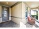 Cozy front porch featuring two chairs, a decorative wreath, and a beautifully designed front door at 14132 Murcott Blossom Blvd, Winter Garden, FL 34787
