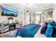 Modern main bedroom with stylish furniture, including a mirrored dresser and a mounted television at 14132 Murcott Blossom Blvd, Winter Garden, FL 34787