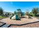 Community playground with various climbing structures, slides, and a wood chip ground cover surrounded by a black metal fence at 14132 Murcott Blossom Blvd, Winter Garden, FL 34787