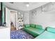 Bright sitting area featuring a modern green sofa, blue striped rug and decorative shelving at 14132 Murcott Blossom Blvd, Winter Garden, FL 34787