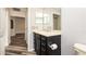 Bathroom with a black vanity, tan countertop, and chrome faucet, complemented by wood-look flooring at 4245 Arlington Ridge Blvd, Leesburg, FL 34748