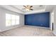 Spacious bedroom with a tray ceiling, new carpet, a large window and freshly painted accent wall at 4245 Arlington Ridge Blvd, Leesburg, FL 34748
