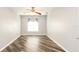 Empty bedroom with vinyl floors, ceiling fan, window with blinds, and neutral paint at 4245 Arlington Ridge Blvd, Leesburg, FL 34748