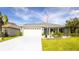Charming single-story home with a well-manicured lawn, flower beds, and long driveway at 4245 Arlington Ridge Blvd, Leesburg, FL 34748