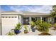 Inviting front porch features decorative planters, a black front door, and a well-manicured garden at 4245 Arlington Ridge Blvd, Leesburg, FL 34748