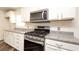 White kitchen with granite countertops and stainless steel stove at 4245 Arlington Ridge Blvd, Leesburg, FL 34748