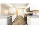 White kitchen with stainless steel appliances and hard wood floors at 4245 Arlington Ridge Blvd, Leesburg, FL 34748