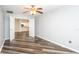Living room area with hardwood floors, ceiling fan, and an open view into the modern kitchen at 4245 Arlington Ridge Blvd, Leesburg, FL 34748