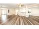 Open concept living and dining room with wood flooring, white walls and trim, and kitchen views at 4245 Arlington Ridge Blvd, Leesburg, FL 34748