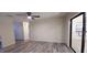 Large living room with light grey wood floors, ceiling fan, and sliding glass door to backyard at 261 Dublin Dr, Lake Mary, FL 32746