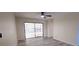 Bright living room with light grey wood floors, ceiling fan, and sliding glass door to the outdoor patio at 261 Dublin Dr, Lake Mary, FL 32746