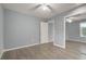 Neutral colored bedroom with wood flooring, ceiling fan, closet with mirror, and opened door at 5783 Peregrine Ave # C07, Orlando, FL 32819