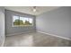 Bedroom with neutral colored walls, wood flooring, and a large window with backyard view at 5783 Peregrine Ave # C07, Orlando, FL 32819