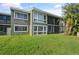 Exterior of the home showcasing a well-maintained lawn and screened patio area with a view to the side at 5783 Peregrine Ave # C07, Orlando, FL 32819