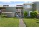 Inviting townhome with lush green grass, mature landscaping, and a quaint front porch with stairs at 5783 Peregrine Ave # C07, Orlando, FL 32819