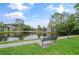 Community pond view with a bench, fountain, and landscaping on a sunny day at 5783 Peregrine Ave # C07, Orlando, FL 32819