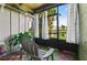 Serene screened porch featuring wood flooring, a comfortable chair, and views of the lush greenery and pond at 5783 Peregrine Ave # C07, Orlando, FL 32819