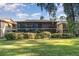 Low angle of a two-story condo featuring an enclosed balcony with a well maintained green space at 120 Hibiscus Woods Ct # 8D, Deltona, FL 32725