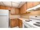 Kitchen showcases wood cabinets, a white fridge, and modern appliances at 120 Hibiscus Woods Ct # 8D, Deltona, FL 32725
