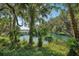 Serene waterfront view with lush tropical landscaping and a wooden dock at 344 Belmond Dr, Debary, FL 32713