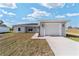 Charming single-story home featuring a gray exterior, attached garage and a concrete driveway at 3590 Sw 150Th Ct, Ocala, FL 34481