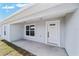 Inviting front entrance featuring a modern white door, a window, and a well-maintained concrete walkway at 3590 Sw 150Th Ct, Ocala, FL 34481