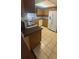 Traditional kitchen with tile flooring, wood cabinetry, white appliances, and a speckled countertop at 4663 Montauk St, Orlando, FL 32808