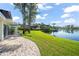 Serene backyard view with lush lawn and a picturesque lake, blending nature and elegance at 8984 Houston Pl # 103, Orlando, FL 32819