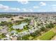 Aerial view showcasing a community with a lake and various houses at 2584 Dividing Creek Path, The Villages, FL 32162