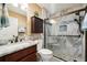 Modern bathroom with granite vanity, updated shower, and frameless glass enclosure at 2584 Dividing Creek Path, The Villages, FL 32162