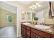 Elegant bathroom with double vanity,dark brown cabinets, and a large mirror at 2584 Dividing Creek Path, The Villages, FL 32162