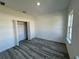Bedroom with gray wood flooring, white walls, closet and window, providing ample natural light at 6208 Sw 129Th St, Ocala, FL 34473