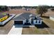 New construction home featuring a black garage door, modern landscaping, and a well-maintained front yard at 6208 Sw 129Th St, Ocala, FL 34473