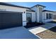 Single-Gathering home featuring a black garage door, modern landscaping, and a welcoming entrance at 6208 Sw 129Th St, Ocala, FL 34473