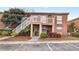 Inviting brick two-story condo building featuring landscaped grounds, a parking lot and stairwell access to upper level units at 476 Banyon Tree Cir # 104, Maitland, FL 32751