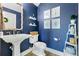 Blue bathroom featuring a pedestal sink, toilet, and decoratively framed art prints on the wall at 772 Stephens Pass Cv, Lake Mary, FL 32746