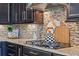 Close-up of a kitchen with granite counters, mosaic backsplash, gas cooktop, and dark wood cabinets at 772 Stephens Pass Cv, Lake Mary, FL 32746