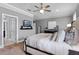 Main bedroom with a neutral color scheme, TV, ceiling fan, and upholstered headboard at 772 Stephens Pass Cv, Lake Mary, FL 32746